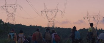 Movie still from “The Swimmers” (2022), directed by Sally El Hosaini – A group of people standing on top of a grass covered field; Extreme Wide shot, Low angle