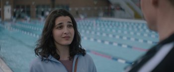 Movie still from “The Swimmers” (2022), directed by Sally El Hosaini – A woman standing in front of an empty swimming pool; Close Up shot, Over the shoulder angle