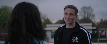 Movie still from “The Swimmers” (2022), directed by Sally El Hosaini – A man standing next to a woman in front of a building; Close Up shot, Over the shoulder angle