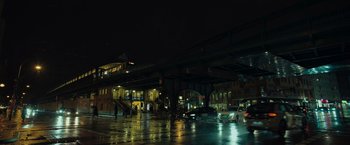 Movie still from “The Swimmers” (2022), directed by Sally El Hosaini – A city street at night lit by street lights; Extreme Wide shot, Low angle