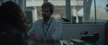 Movie still from “The Swimmers” (2022), directed by Sally El Hosaini – A man sitting at a table in front of a window; Medium shot, Over the shoulder angle