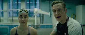 Movie still from “The Swimmers” (2022), directed by Sally El Hosaini – A man and a woman are posing for a picture; Close Up shot, Over the shoulder angle