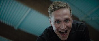Movie still from “The Swimmers” (2022), directed by Sally El Hosaini – A person smiling with his mouth wide open; Close Up shot, Low angle