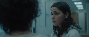 Movie still from “The Swimmers” (2022), directed by Sally El Hosaini – A young woman looking at a mirror in a room; Close Up shot, Over the shoulder angle