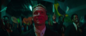 Movie still from “The Swimmers” (2022), directed by Sally El Hosaini – A person wearing a suit and tie; Close Up shot, Low angle