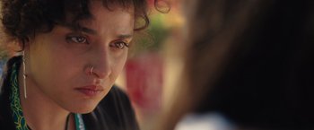 Movie still from “The Swimmers” (2022), directed by Sally El Hosaini – A woman's face with a blurry background; Close Up shot, Over the shoulder angle