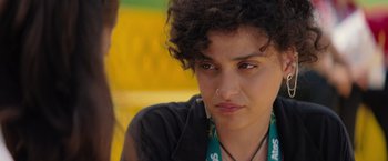 Movie still from “The Swimmers” (2022), directed by Sally El Hosaini – A person wearing a necklace; Close Up shot, Over the shoulder angle