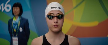 Movie still from “The Swimmers” (2022), directed by Sally El Hosaini – A woman wearing goggles and a swim cap; Close Up shot, Low angle