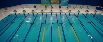 Movie still from “The Swimmers” (2022), directed by Sally El Hosaini – A group of people in a swimming pool; Extreme Wide shot, High angle
