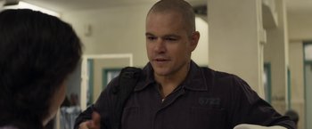 Movie still from “Elysium” (2013), directed by Neill Blomkamp – A man in a black shirt is looking at the camera; Close Up shot, Over the shoulder angle