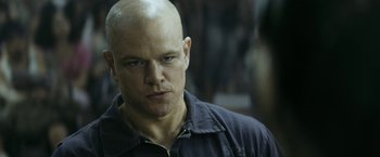 Movie still from “Elysium” (2013), directed by Neill Blomkamp – A man with a bald head is looking at the camera; Close Up shot, Over the shoulder angle