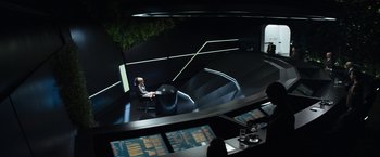 Movie still from “Elysium” (2013), directed by Neill Blomkamp – A man sitting at a desk in a dark room; Wide shot, High angle