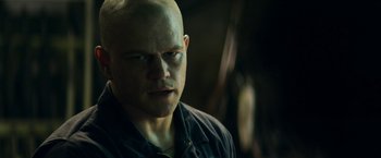Movie still from “Elysium” (2013), directed by Neill Blomkamp – A bald man with green eyes stares into the distance; Close Up shot, Over the shoulder angle