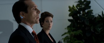 Movie still from “Elysium” (2013), directed by Neill Blomkamp – A man and a woman in business attire looking at a plant; Close Up shot, Low angle