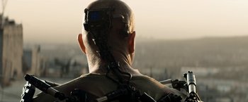 Movie still from “Elysium” (2013), directed by Neill Blomkamp – A man with a camera attached to the back of his head; Close Up shot, Low angle