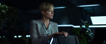 Movie still from “Elysium” (2013), directed by Neill Blomkamp – A woman with short blonde hair wearing a gray jacket; Medium shot, Low angle
