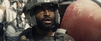 Movie still from “Elysium” (2013), directed by Neill Blomkamp – A person with a helmet on; Close Up shot, Over the shoulder angle