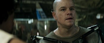 Movie still from “Elysium” (2013), directed by Neill Blomkamp – A bald man with a tattoo on his face; Close Up shot, Over the shoulder angle