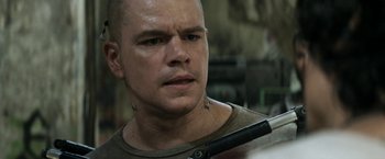 Movie still from “Elysium” (2013), directed by Neill Blomkamp – A person holding a gun; Close Up shot, Over the shoulder angle