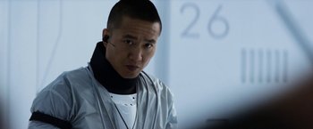 Movie still from “Elysium” (2013), directed by Neill Blomkamp – A man in a white shirt and a black neck tie; Close Up shot, Over the shoulder angle