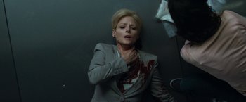 Movie still from “Elysium” (2013), directed by Neill Blomkamp – A woman in a gray jacket with blood on her chest; Medium shot, Overhead angle