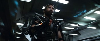 Movie still from “Elysium” (2013), directed by Neill Blomkamp – A man with a beard holding a sword in his hands; Medium shot, Low angle