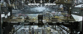 Movie still from “Elysium” (2013), directed by Neill Blomkamp – An industrial building with many large parts in it; Extreme Wide shot, High angle