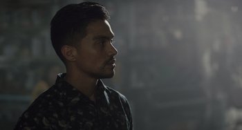 Movie still from “The Tax Collector” (2020), directed by David Ayer – A person wearing a camouflage shirt; Close Up shot, Low angle