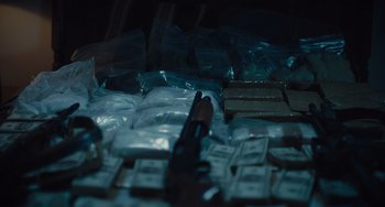 Movie still from “The Tax Collector” (2020), directed by David Ayer – A gun sitting on top of a pile of drugs; Extreme Close Up shot, High angle