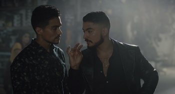 Movie still from “The Tax Collector” (2020), directed by David Ayer – Two men standing next to each other and one of them is smoking a cigarette; Close Up shot, Over the shoulder angle