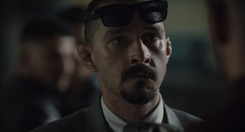 Movie still from “The Tax Collector” (2020), directed by David Ayer – A person wearing a suit and sunglasses; Close Up shot, Low angle