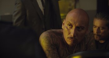 Movie still from “The Tax Collector” (2020), directed by David Ayer – A man with a beard and tattoos is sitting in front of a mirror; Close Up shot, Over the shoulder angle