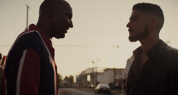 Movie still from “The Tax Collector” (2020), directed by David Ayer – Two men standing next to each other on the street; Medium shot, Over the shoulder angle