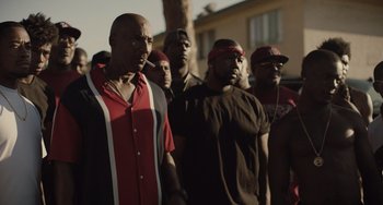 Movie still from “The Tax Collector” (2020), directed by David Ayer – A group of men standing next to each other in front of a building; Medium shot, High angle