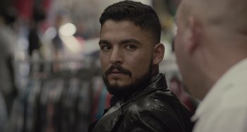 Movie still from “The Tax Collector” (2020), directed by David Ayer – A person wearing a leather jacket; Close Up shot, Over the shoulder angle