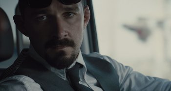 Movie still from “The Tax Collector” (2020), directed by David Ayer – A person wearing a suit and tie; Close Up shot, Over the shoulder angle
