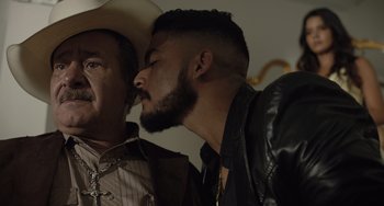 Movie still from “The Tax Collector” (2020), directed by David Ayer – A man with a beard and a cowboy hat on; Close Up shot, Over the shoulder angle