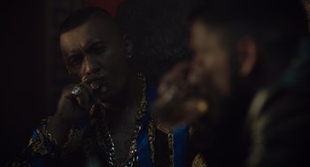 Movie still from “The Tax Collector” (2020), directed by David Ayer – A man smoking a cigarette while another man is smoking a cigarette; Close Up shot, Over the shoulder angle