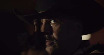 Movie still from “The Tax Collector” (2020), directed by David Ayer – A person wearing a hat; Extreme Close Up shot, Low angle