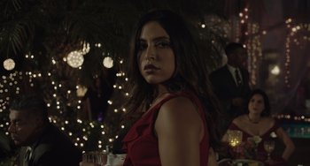 Movie still from “The Tax Collector” (2020), directed by David Ayer – A woman in a red dress standing in front of a christmas tree; Close Up shot, Over the shoulder angle