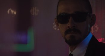Movie still from “The Tax Collector” (2020), directed by David Ayer – A person wearing a suit and sunglasses; Close Up shot, Low angle