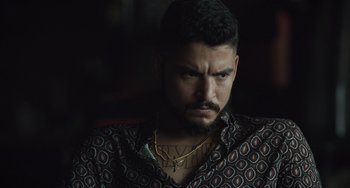 Movie still from “The Tax Collector” (2020), directed by David Ayer – A person wearing a shirt and a necklace; Close Up shot, Over the shoulder angle