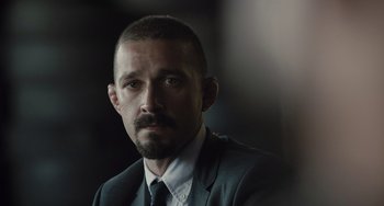 Movie still from “The Tax Collector” (2020), directed by David Ayer – A person wearing a suit and tie; Close Up shot, Over the shoulder angle