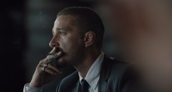 Movie still from “The Tax Collector” (2020), directed by David Ayer – A person wearing a suit smoking a cigarette; Close Up shot, Low angle