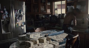 Movie still from “The Tax Collector” (2020), directed by David Ayer – A room filled with lots of boxes and papers; Wide shot, Over the shoulder angle