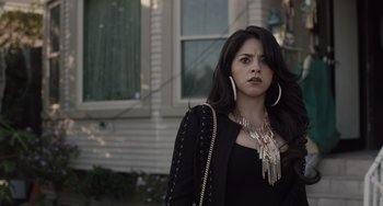 Movie still from “The Tax Collector” (2020), directed by David Ayer – A woman with long black hair wearing a black jacket; Close Up shot, Over the shoulder angle
