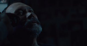 Movie still from “The Tax Collector” (2020), directed by David Ayer – A man with a gray beard looking up at the sky; Extreme Close Up shot, High angle