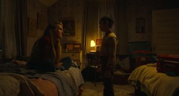 Movie still from “The Tender Bar” (2021), directed by George Clooney – A woman sitting on a bed talking to a boy; Medium shot, High angle