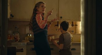 Movie still from “The Tender Bar” (2021), directed by George Clooney – A woman and a child in a kitchen; Medium shot, Over the shoulder angle