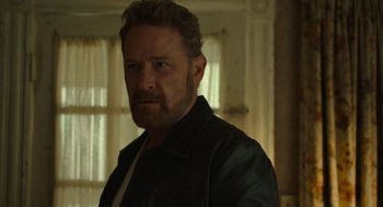 Movie still from “The Tender Bar” (2021), directed by George Clooney – A person with a beard wearing a leather jacket; Close Up shot, Over the shoulder angle